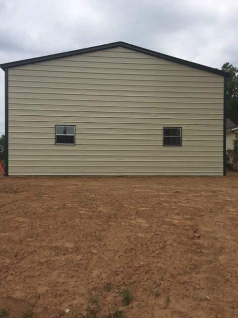 Back of a double wide garage building, depicting two windows.