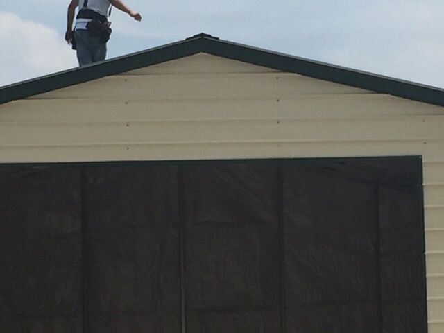Photo of a crew member standing on top of a commercial garage.