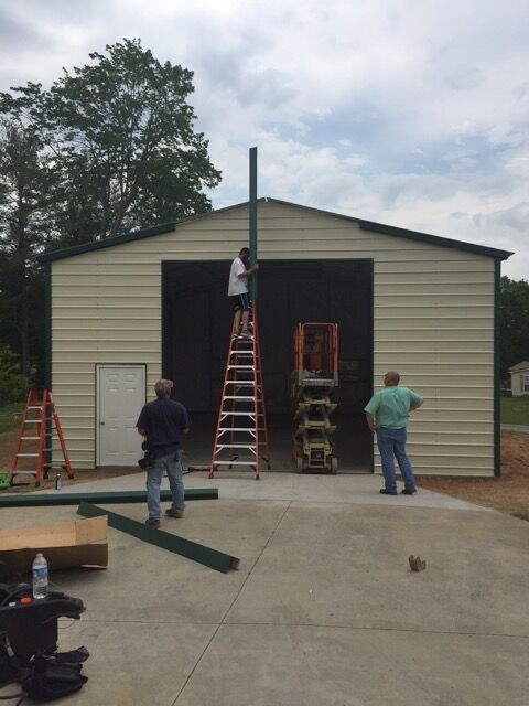 Crew building a commercial metal garage, attaching the trim.