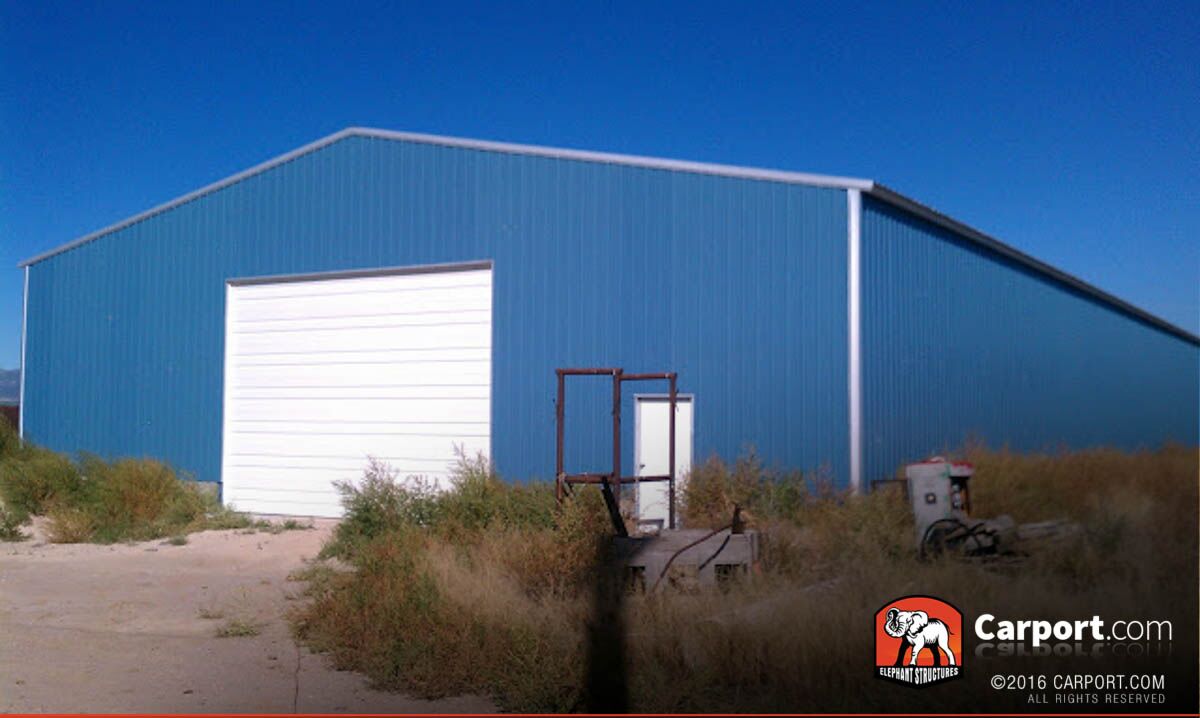 50x100x14 Commercial metal garage building 50 x 100 with blue walls and white trim, one roll up garage door and walk in door.