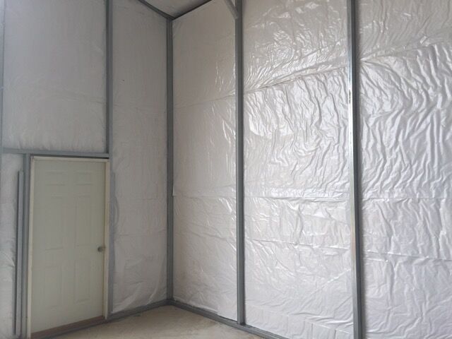 Inside view of commercial metal garage with insulation and man door.